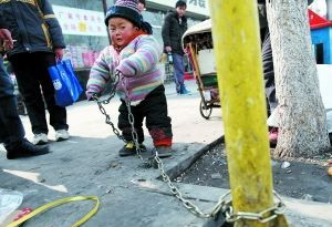 两岁男童被用铁链拴在街边 称怕丢了