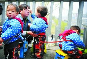 绳拴2岁三胞胎 一女子在北京街头乞讨