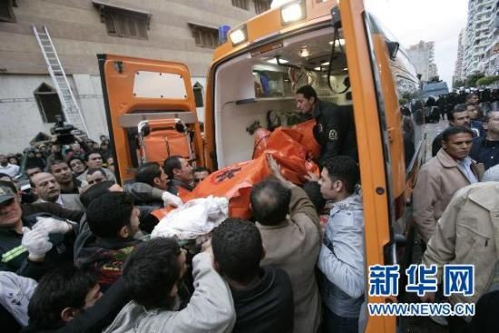 1月1日,在埃及北部港口城市亚历山大发生爆炸的教堂附近,医护人员将伤者抬上救护车。 新华社发(纳赛尔·努里摄)