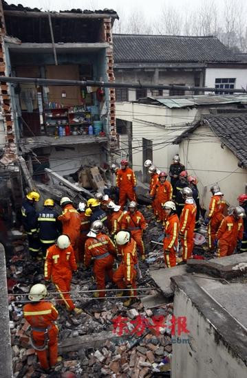 民宅被炸后仅剩“半壁江山”,救援人员正在废墟中搜寻。早报记者 赵昀 图