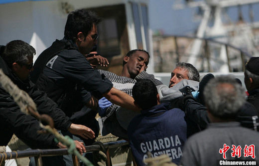 图为幸存难民在当地救援人员的帮助下抵达意大利。