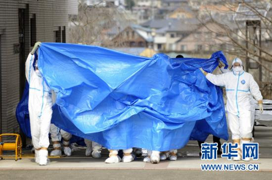 这张由日本共同社3月25日提供的照片显示,在福岛县医科大学附属医院,日本福岛第一核电站遭受过量辐射的工作人员在防护罩的保护下去接受去污 治疗(3月25日摄)。新华社/共同社