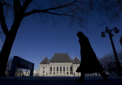 依照加拿大最高法院10日終審裁定，「不良新移民」領取的政府救濟金，擔保人要承擔。圖為一名行人步行經過加拿大最高法院。（加通社）