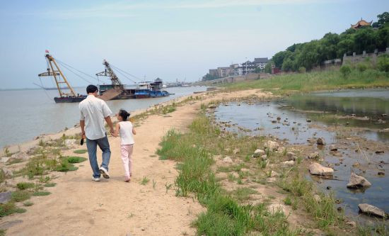 行人从岳阳楼景区围墙外的洞庭湖边经过。新华社记者 周科 摄