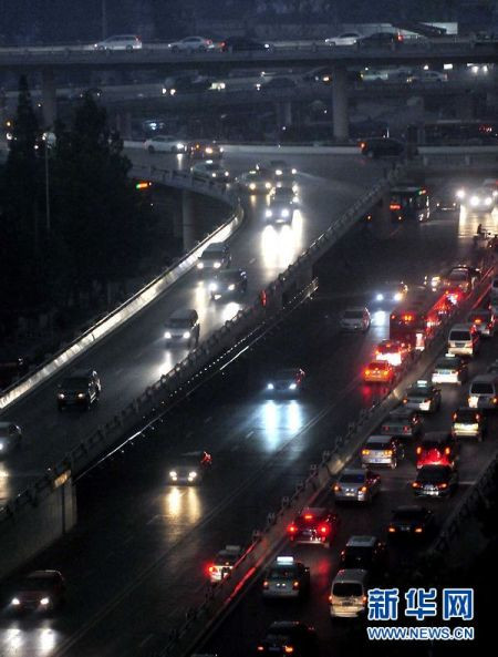 7月26日，在郑州市区的一座立交桥上，汽车开灯缓慢行驶。当日下午，郑州市区阴云密布，宛如黑夜，随即出现雷电，并伴有大风和强降水，当地气 象部门已发布雷电黄色预警信号。新华社记者 王颂 摄