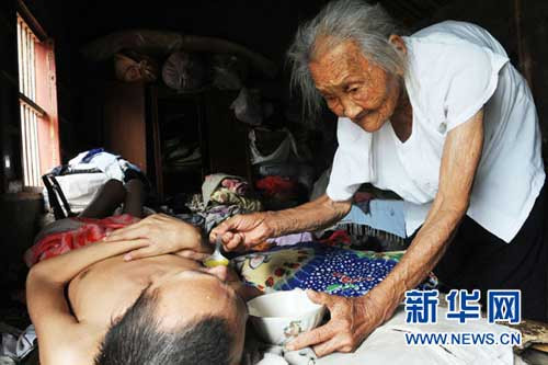 95岁驼背母亲照顾60岁瘫儿亲手喂饭端尿盆（图）