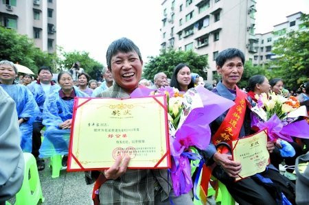 昨日,巴南区花溪街道先锋村,获得“好公婆”称号的村民展示自己的奖状。