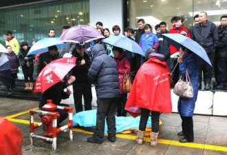 老人街头瘁死 过路人雨中撑伞护遗体