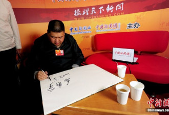 两会花絮：毛新宇接受采访现场秀书法
