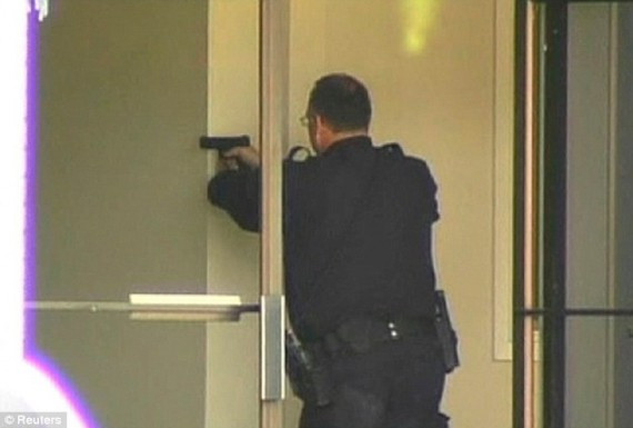 A police officer aims his handgun as he enters the Christian college where a gunman went on the rampage. The suspect was later arrested nearby