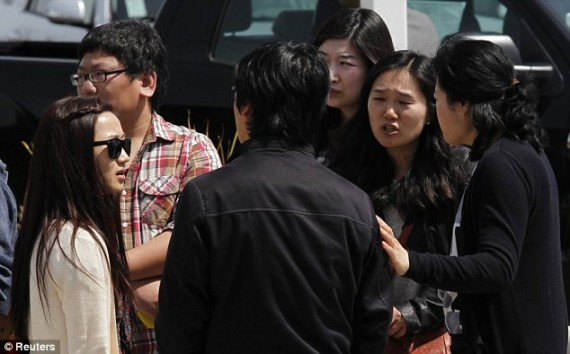 Students talk among themselves at the scene of the deadly shooting on Monday
