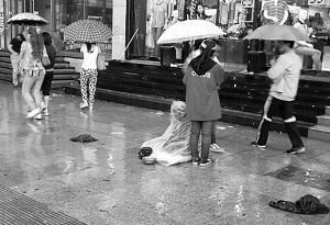 好心女孩为乞讨老人撑伞挡雨 被开除