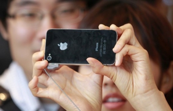 A woman takes a picture of herself using Apple's iPhone 4 during the phone's launch at the headquarters of KT in Seoul