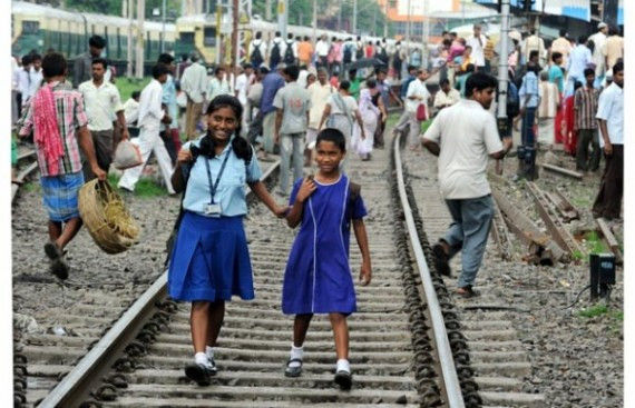 Indian school girls walk on the tracks a