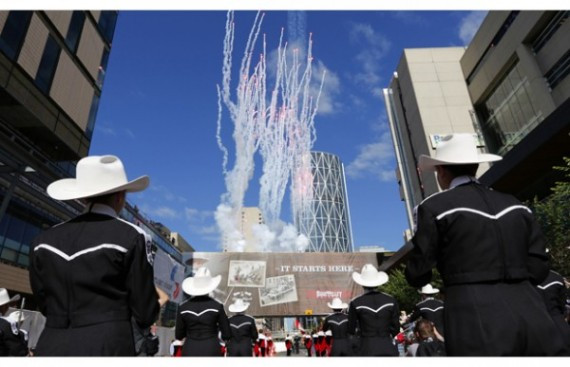 Fireworks go off over the Calgary Stampede Marching Band at the start of the annual Stampede rodeo parade during the 100th anniversary of the Calgary Stampede in Calgary