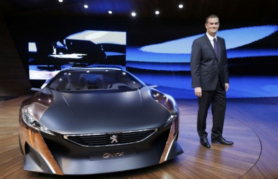 Director General of Peugeot Maxime Picat poses next to a Peugeot Onyx concept-car on media day at the Paris Mondial de l'Automobile