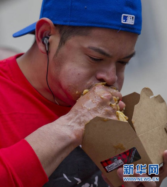 10月13日，在多伦多邓达斯广场，一位选手在吃&ldquo;普丁&rdquo;比赛中。