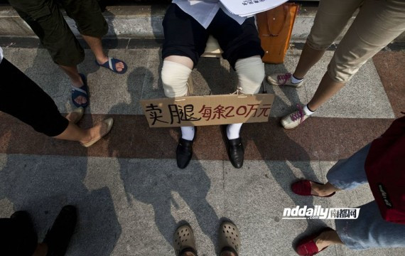 广州男子工伤索赔无果 天桥上举牌卖腿每条20万讨公道(图)