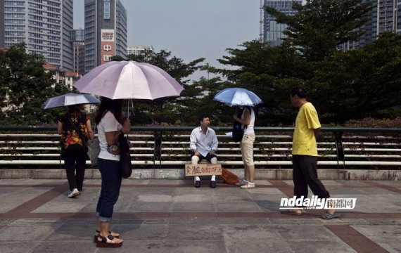 广州男子工伤索赔无果 天桥上举牌卖腿每条20万讨公道(图)