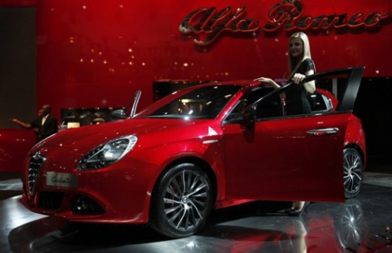 A model poses next to an Alfa Romeo Giulietta car on media day at the Paris Mondial de l'Automobile