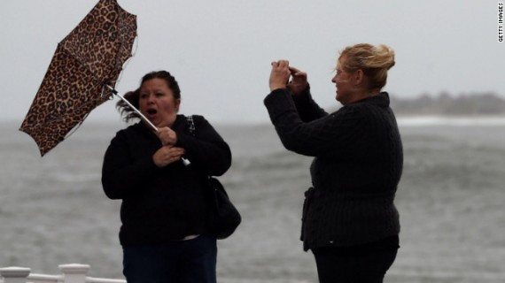 Lisa Cellucci holds her umbrella as it is blown backward by Hurricane Sandy's winds as her friend Kim Vo watches on Sunday in Cape May.