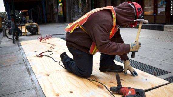 A construction worker covers air vents Sunday to try to prevent the New York subway system from flooding by Hurricane Sandy. New York Gov. Andrew Cuomo announced a shutdown and suspension of all subway, bus and commuter rail service in response to the storm. 