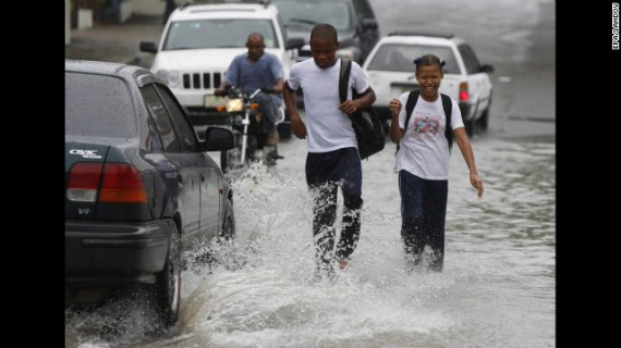 Students walk in floodwater from Hurricane Sandy's rain in Santo Domingo on Wednesday.