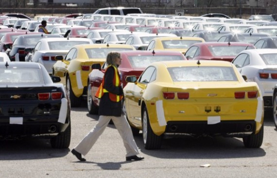 A worker walks by 2010 Chevy Camaro's in a holding yard at the General Motors assembly plant in Oshawa