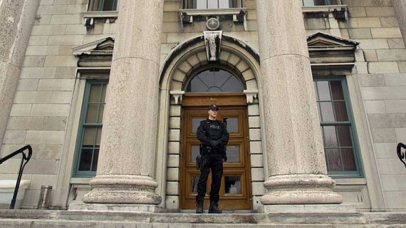 A policeman stands at the entrance to the Frontenac County courthouse in Kingston, Ont., where the so-called honour-killing trial of the Shafia family took place. Tweeting from inside the courtroom was banned outright. 