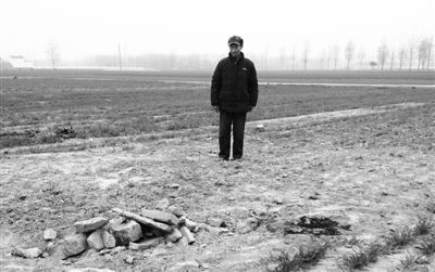 11月22日，张方站在父母的坟前，墓碑已被推倒掩埋。挖墓碑时，他的三儿媳和二妹夫被倒下的墓碑砸死。新京报记者 孟祥超 摄