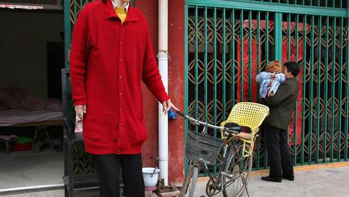 Tallest woman in Asia Chinese stands at entrance of her home in Shu Cha in eastern China's Anhui province