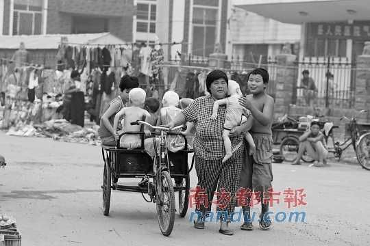 2006年7月21日，河南兰考县，袁厉害和收养的弃儿。资料图片