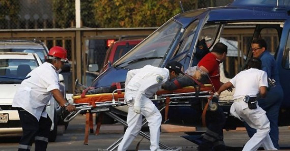 Paramedics wheel an injured person to a helicopter at the parking lot of the state-run oil company Pemex after an explosion in Mexico City