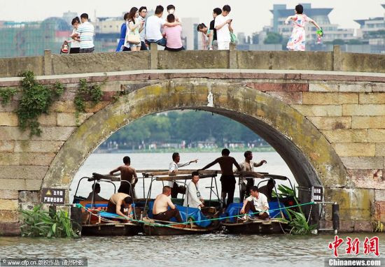 6月17日,杭州最高气温达36.4℃,跨入了气温“3”时代。在西湖断桥,西湖游船的船老大们纷纷“躲”进了断桥的桥洞内避暑。吴煌 摄 图片来源:CFP视觉中国