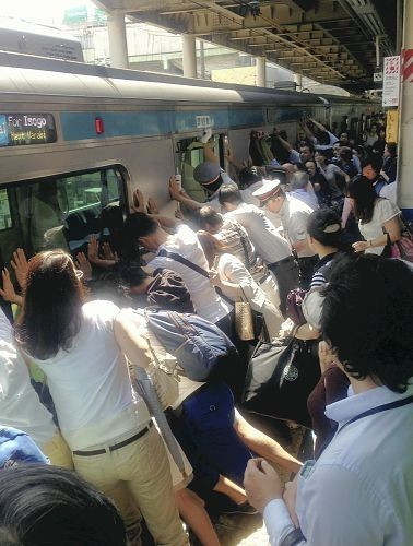 感人一幕：日本一女子被电车卡住 众多乘客推车将其救出(多图)