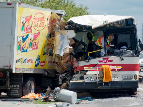 Emergency crews work at the scene where a TTC bus and commercial food truck collided on Steeles Avenue East and Middlefield Road in Scarborough, Ontario, Tuesday.