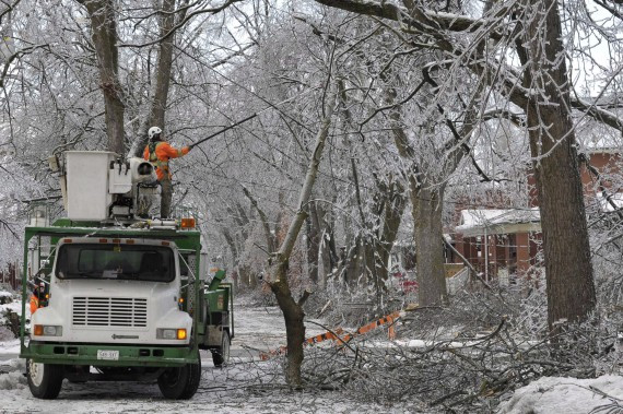 Crews clear branches snagged on power lines on a closed road in Brampton. THE CANADIAN PRESS/J.P. Moczulski