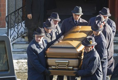 加拿大黑手黨首領維托．瑞佐托葬禮昨天舉行，圖為一式長大衣加義大利式禮帽裝束的抬棺者，將靈柩抬入守候在教堂門前的靈車。（加通社） 