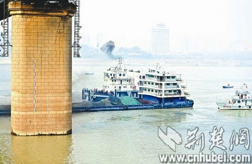 图为：事故货轮被拖离现场。