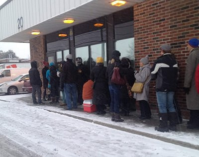 食物卡領取首日，位於多倫多市服務中心開門前，即有數十市民排隊等候。（本報資料照片） 