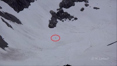 圖中人形「黑點」(紅圈),短短幾分鐘就從遠處雪地向山脊移動。 (取自Youtube畫面)