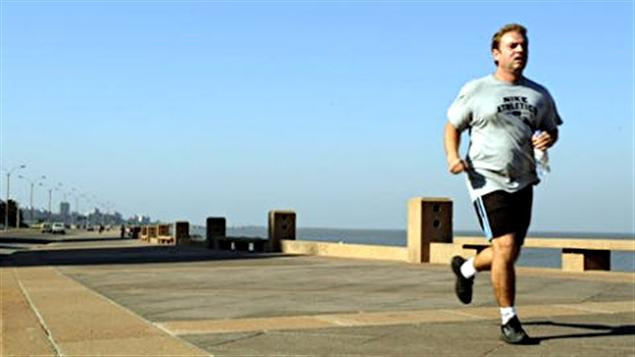 Homme faisant du jogging sur le bord d'un cours d'eau