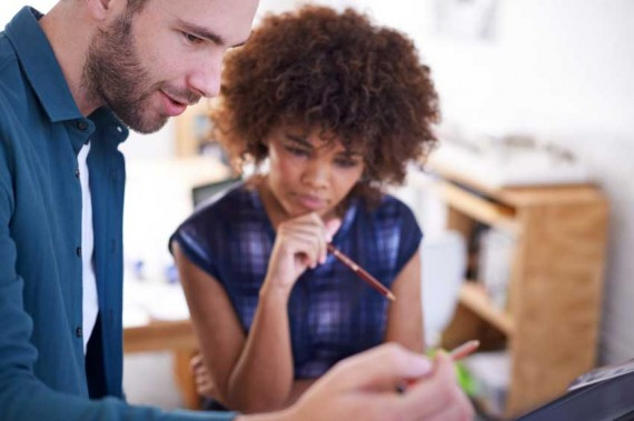 Two professionals looking at a computer
