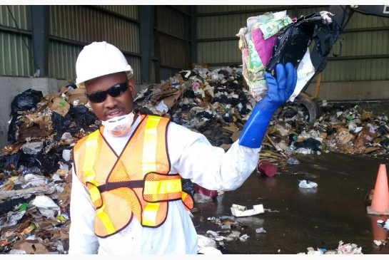 A relieved Joseph Grant after sorting through nine tonnes of garbage with Carmen's staff and others, holding some of the recovered cash envelopes that were part of his wedding gifts.