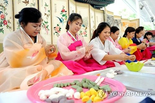 22日上午，在韩国首尔，来自多元文化家庭（国际婚姻家庭）女性们聚集一堂，参加制作韩国传统中秋食品——松饼的活动