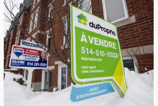 For sale signs are seen in front of a Montreal condominium in this file photo. A new report on real estate trends predicts that foreign investors could start looking beyond Toronto and Vancouver and towards markets such as Montreal and Saskatoon in the year ahead.