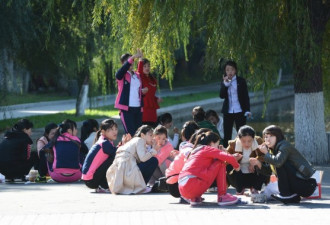 朝鲜在华女学生出游 集体蹲街头进餐