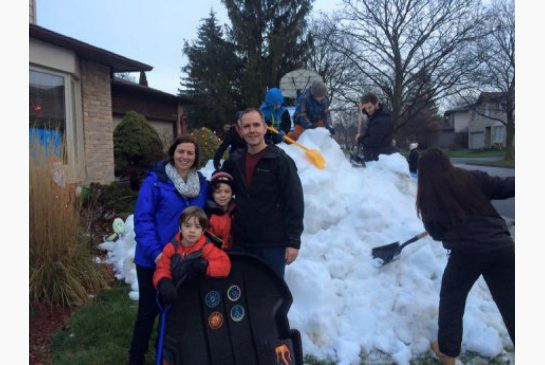 Contest winner Lucas, 6, his older brother Adam, 8, and parents enjoy the pile of snow delivered early Wednesday morning.