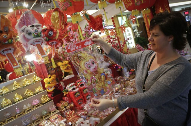 春节来临，在加拿大大温哥华地区里士满市，当地市民纷纷来到室内年宵花市��买猴年装饰品，以迎接春节来临。（新华社）
