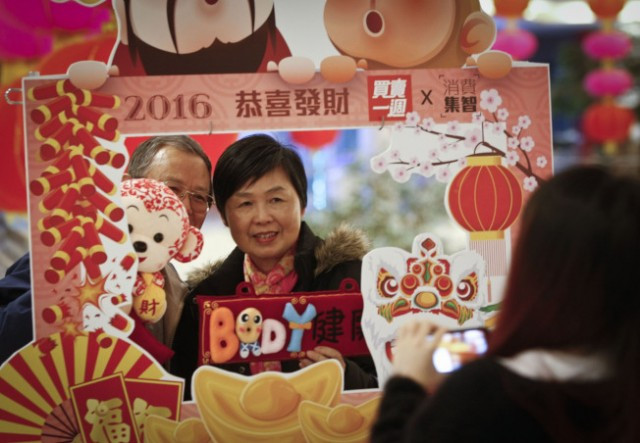 春节来临，在加拿大大温哥华地区里士满市，当地市民纷纷来到室内年宵花市��买猴年装饰品，以迎接春节来临。（新华社）
